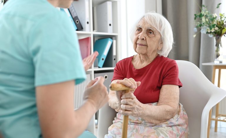 Medical Worker Holds Elderly Woman'S Hands